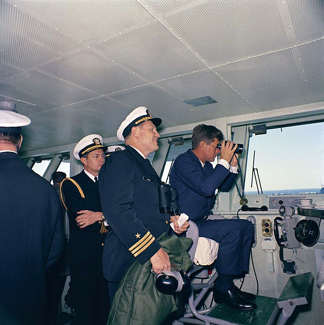 President Kennedy aboard USS Enterprise (CVN-65), watching maneuvers, April 1962